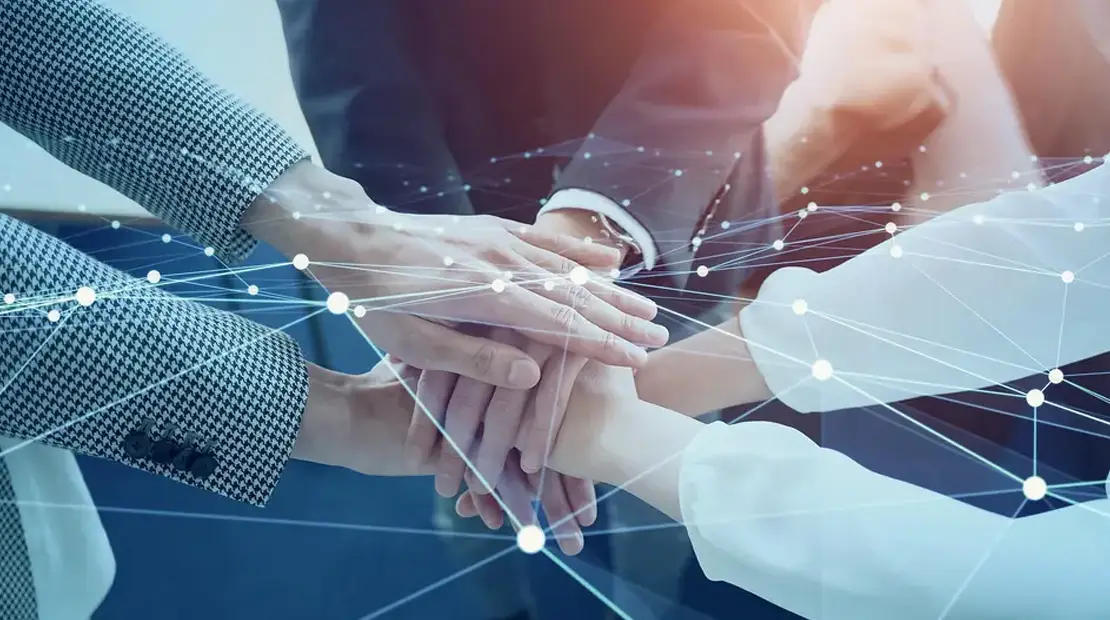 Mani sovrapposte in segno di collaborazione, con rete digitale a connessione simbolica sovrapposta.